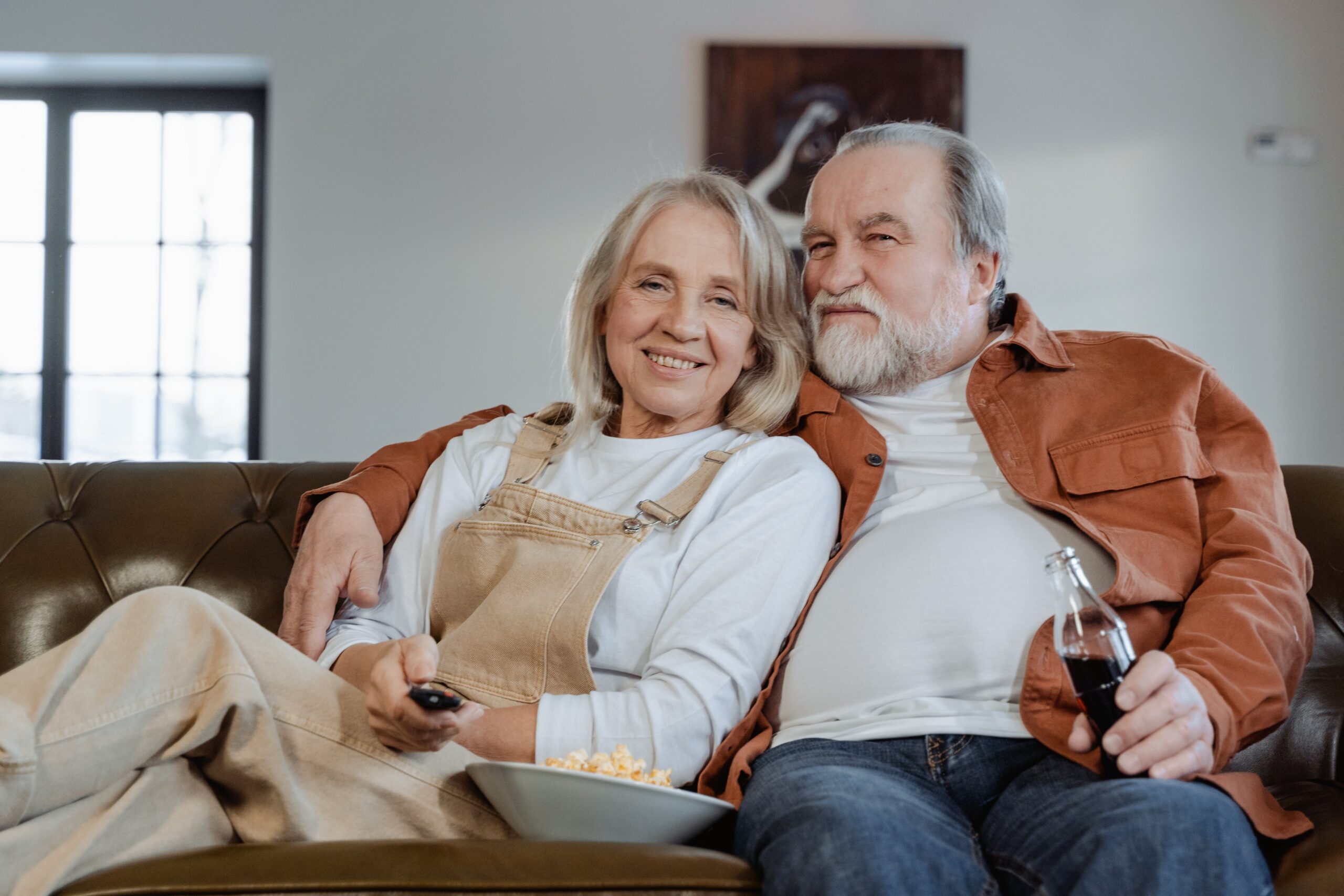 Retired couple sitting on a couch relaxing.