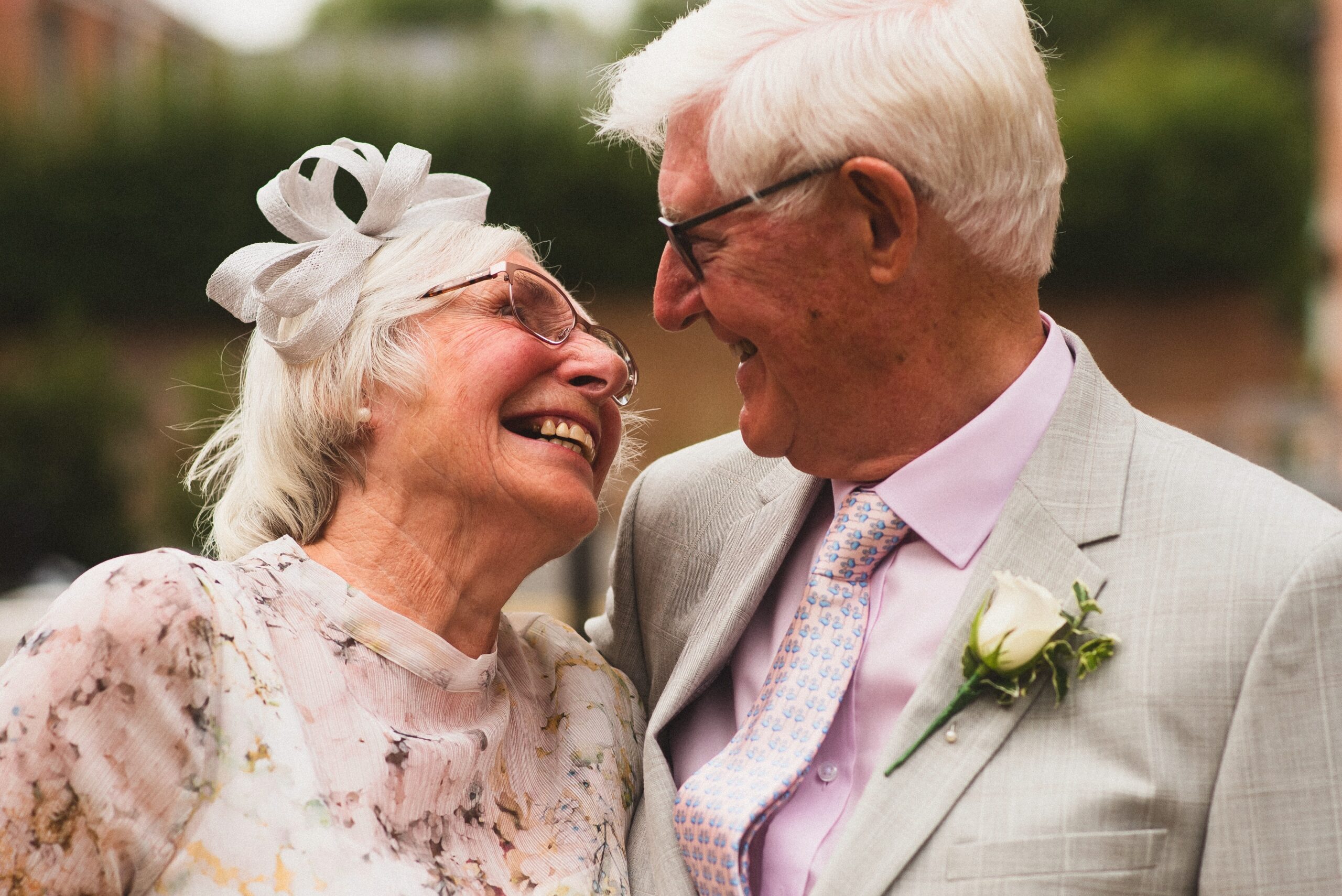 Older couple, looking at each other smiling, in formal wear.
